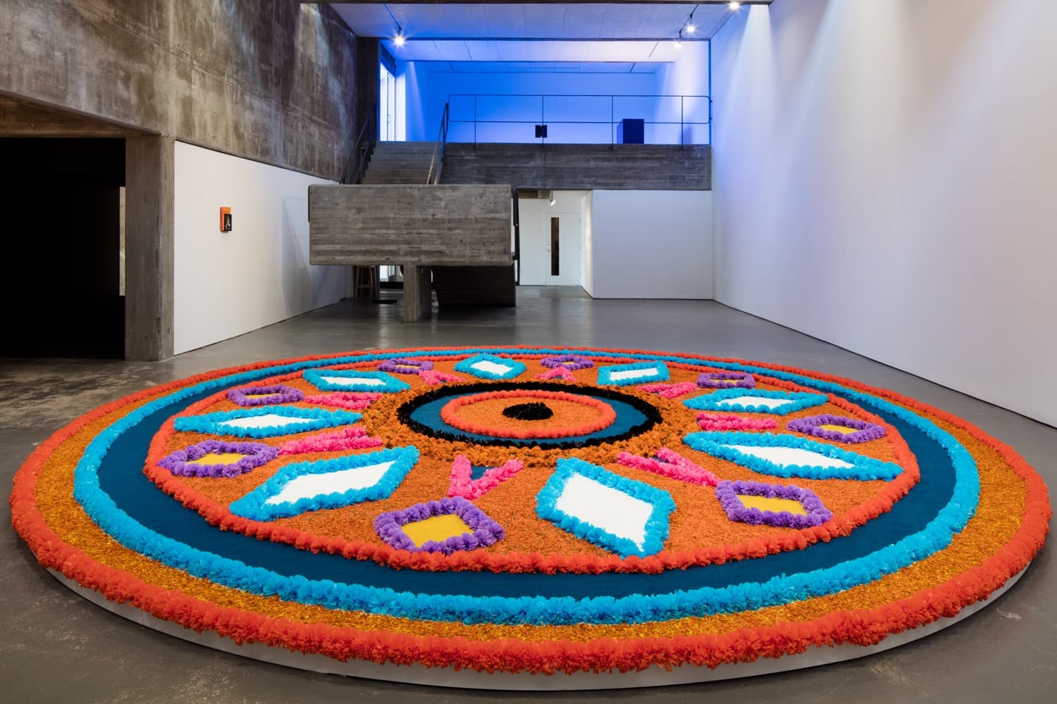 Installation View, The Offering (Tapete de Flores), 2016 . Artificial flowers, natural flowers, dyed sawdust, salt, glue . 8 meters in diameter.